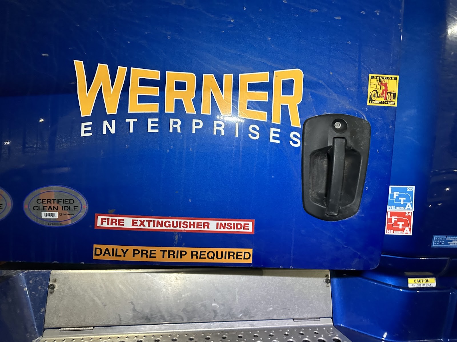 Blue Werner Enterprises truck cab door with safety decals